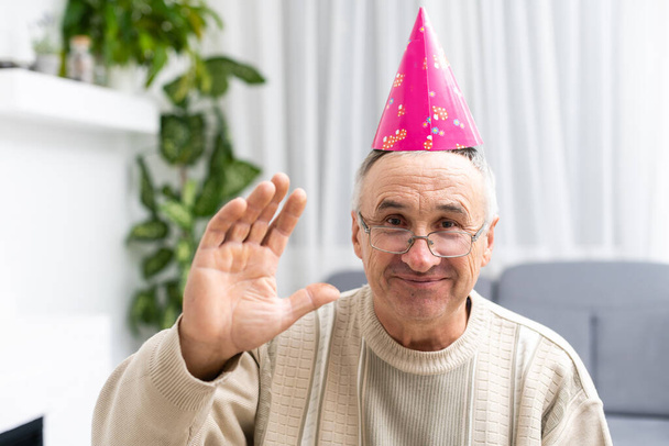 Retrato del anciano feliz en una gorra de fiesta - Foto, imagen