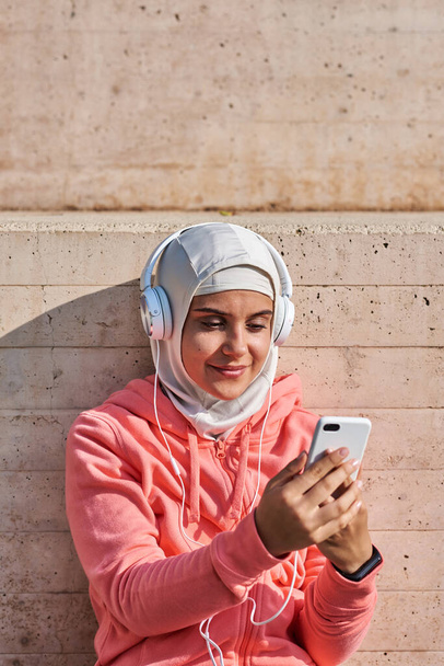 Muslim young woman with headphones taking a break - 写真・画像
