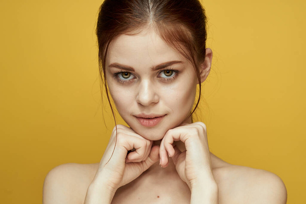 pretty woman naked shoulders and posing clear skin yellow background - Fotografie, Obrázek