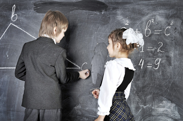 少年と少女が黒板に書く - 写真・画像