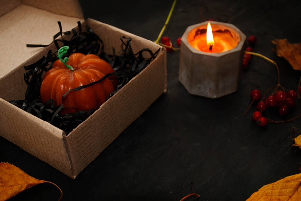 Gezellige herfststemming. Decoratieve kaarsen in de vorm van een pompoen. Herfst concept, warm thuis scène. Selectieve focus.  - Foto, afbeelding