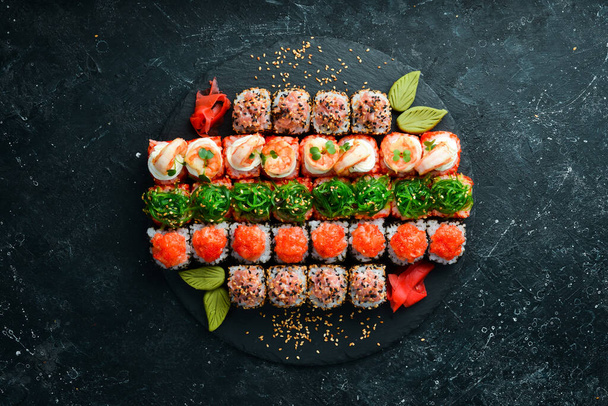 Top view. set of sushi rolls on a black stone plate. Traditional Japanese food. On a black stone background. - Valokuva, kuva