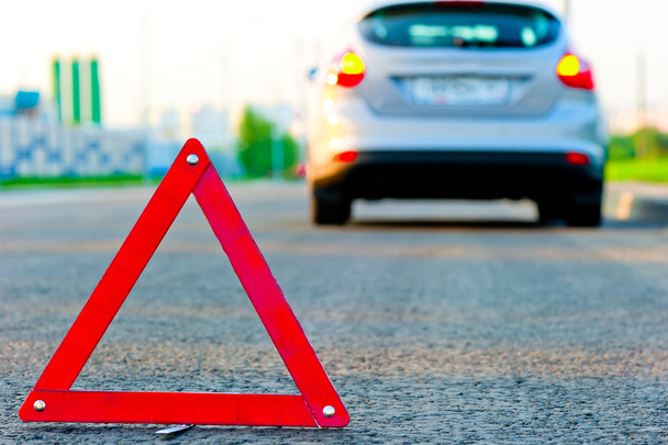 triángulo de advertencia en la carretera y el coche se movió hacia abajo a la acera
 - Foto, imagen