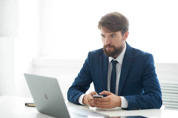 üzletember öltönyben nyakkendővel ül egy asztalnál egy laptop kommunikáció előtt - Fotó, kép