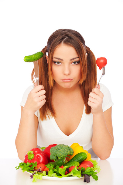 Жінка сидить біля тарілки з овочами
 - Фото, зображення