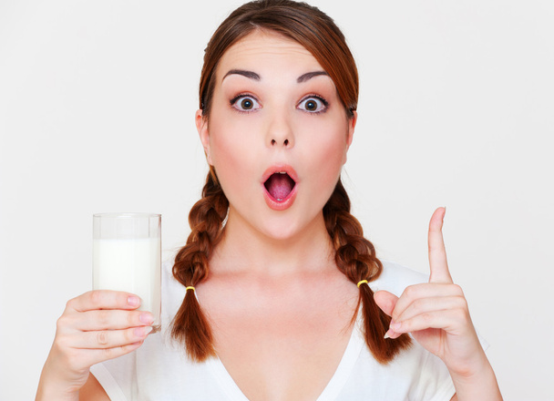 Young woman holding glass of milk - Фото, изображение