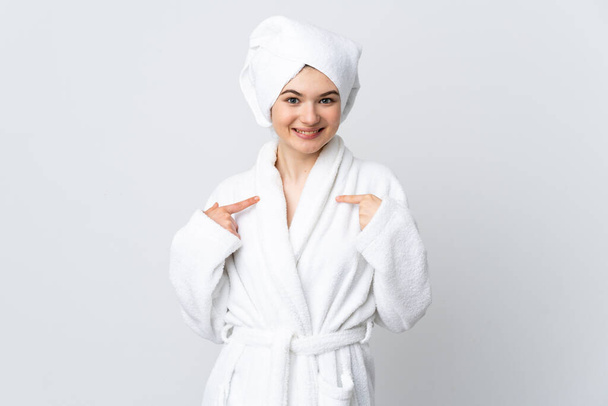Adolescente menina em um roupão de banho isolado no fundo branco com expressão facial surpresa - Foto, Imagem