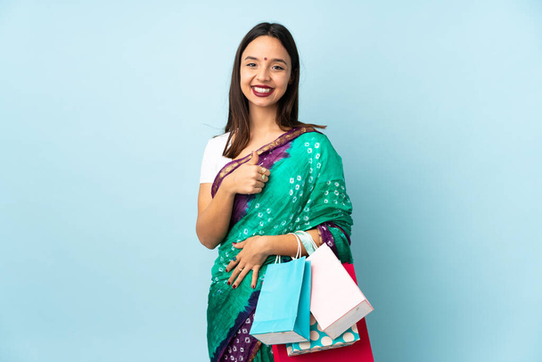 Молода індійська жінка з сумками для покупок дає великий жест. - Фото, зображення