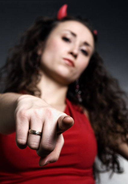 Kırmızı boynuzlu işaret eden genç kadın - Fotoğraf, Görsel