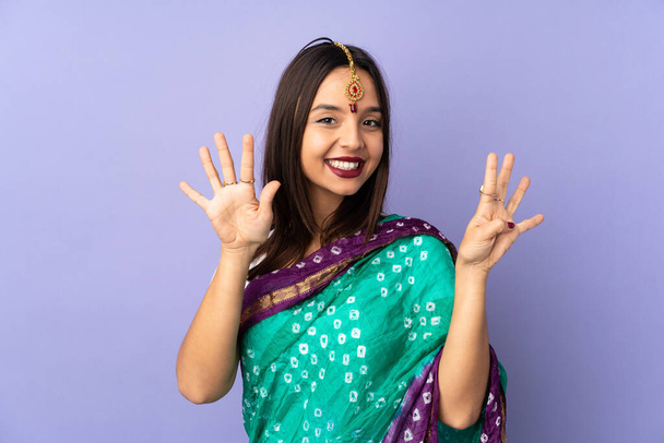 Mujer india joven aislada sobre fondo púrpura contando nueve con dedos - Foto, Imagen