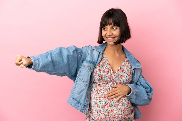 Giovane donna incinta su isolato sfondo rosa dando un pollice in su gesto - Foto, immagini
