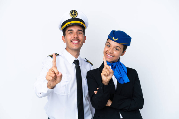Airplane pilot and mixed race air hostess isolated on white background showing and lifting a finger - Foto, Imagen