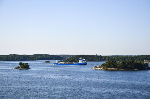 船はスウェーデンのストックホルム諸島の小さな岩の島を航行します - 写真・画像