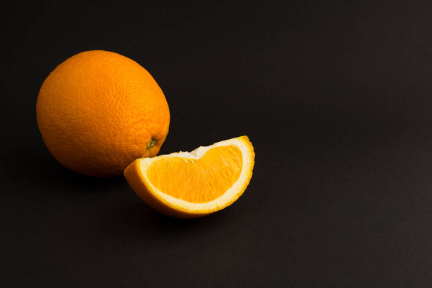 Close-up on orange - fruit on the black background. Copy space. - Foto, Imagen