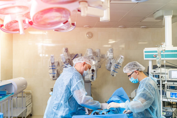 Surgeons working in operating room. Surgeons working in operating room. Hospital background. Two male doctors at work. Background of an operation - Foto, afbeelding