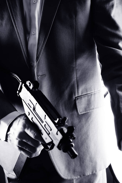 Agent secret rétro avec mitrailleuse en main vintage crime thriller photo maquette.        - Photo, image