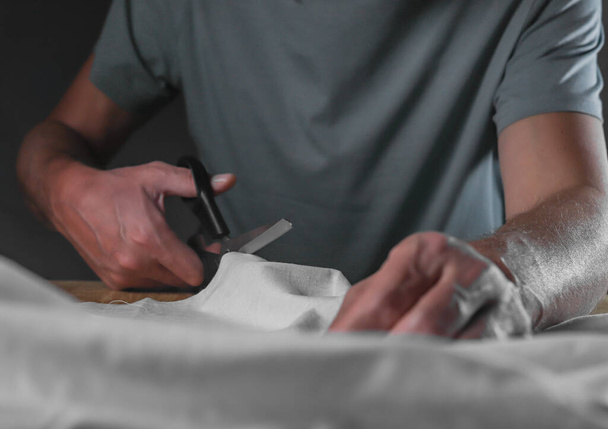 Male hands cutting cotton cloth with sewing scissors - Φωτογραφία, εικόνα