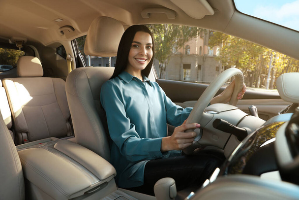 Beautiful young driver sitting in modern car - Photo, image