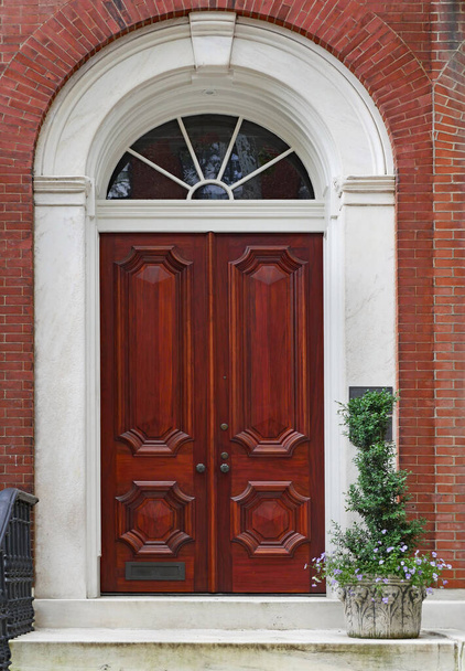 Елегантні дерев'яні подвійні двері з червоного дерева, вхід в старий таунхаус або багатоквартирний будинок
. - Фото, зображення