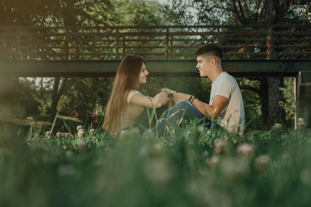 Két szerelmes fiatal ül a fűben.. - Fotó, kép