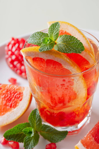 Grapefruit and pomegranate cocktail or mocktail, refreshing summer drink with crushed ice and sparkling water - Photo, Image