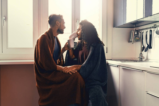 Ein schwules männliches Paar trinkt morgens Milch. Zwei Homosexuelle umarmen sich unter einer Decke. - Foto, Bild
