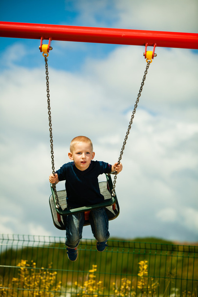 Little blonde boy having fun on a swing outdoor - Photo, Image