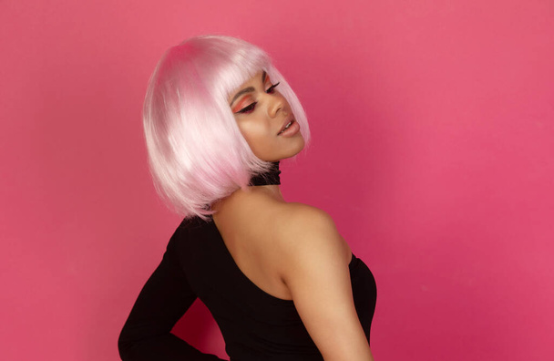 beautiful young sexy african american woman with pink hair posing on pink background - Foto, imagen