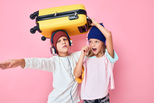 Портрет дівчини і хлопчика, який готується до свят молодих мандрівників рожевого кольору фону
 - Фото, зображення