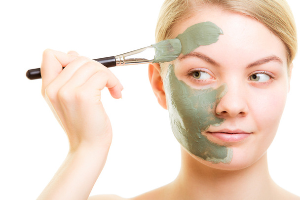Skin care. Woman applying clay mud mask on face. - Фото, изображение