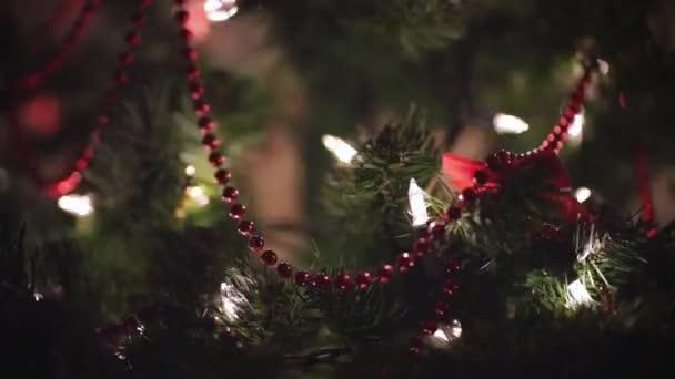  Розмиті різдвяні прикраси на красивій прикрашеній різдвяній ялинці з боке світлом у вітальні вночі. Концепція підготовки і очікування нового року
. - Кадри, відео
