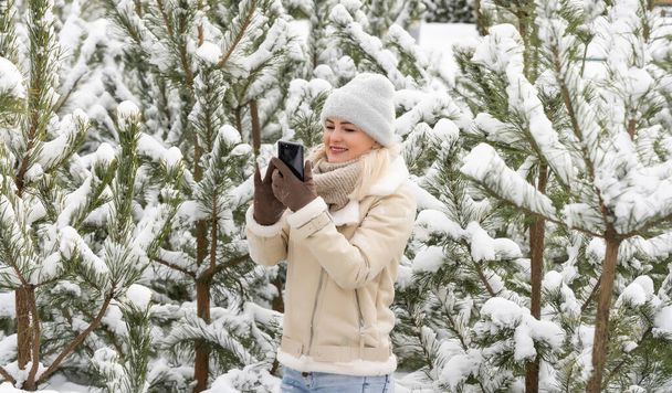 woman takes selfie in the snow covered forest during a winter adventure. - Photo, Image