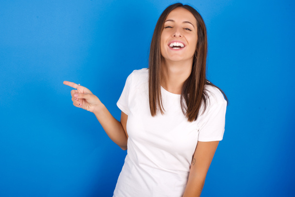 krásná mladá žena se šťastně směje ukazuje na prázdné místo demonstruje nákupní slevu nabídku, vzrušený dobrou zprávou nebo neočekávaný prodej. - Fotografie, Obrázek