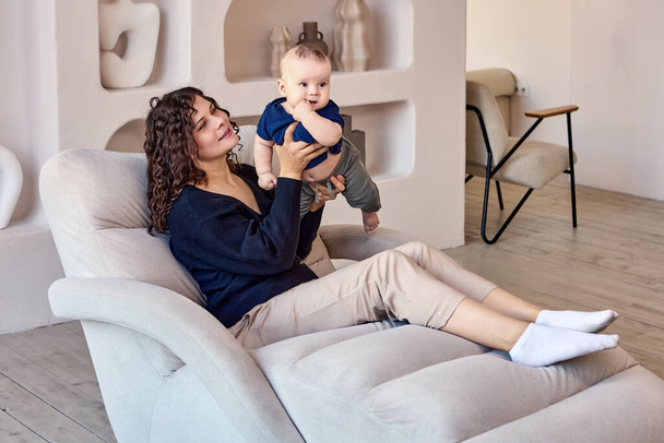 Couch in living room with woman who holds child. - Photo, image
