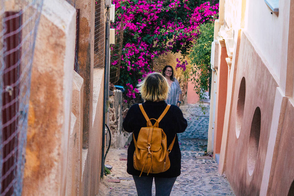 Santorini, Oia, Grecia - 18 de octubre de 2021 Multitud de turistas visitan la famosa ciudad encaramada de Oia durante la epidemia de coronavirus que azotó Grecia, usar una máscara en la calle no es obligatorio. - Foto, Imagen