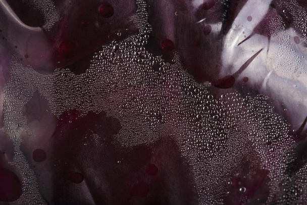 water druppels op plastic verpakking met rode kool - Foto, afbeelding