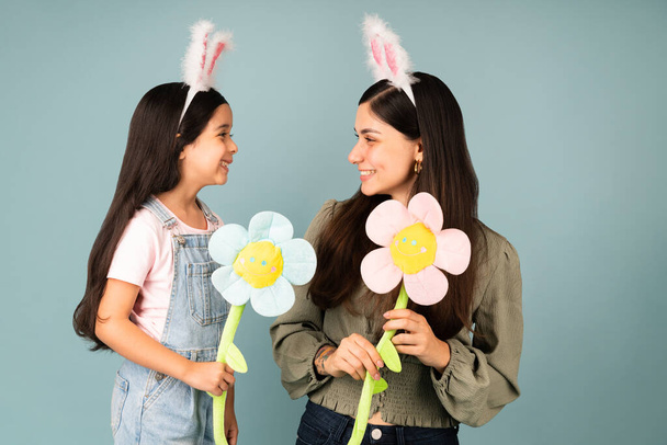 Весна тут. Прекрасна молода мама і мила маленька дівчинка з вухами кролика збуджена на Великдень
 - Фото, зображення