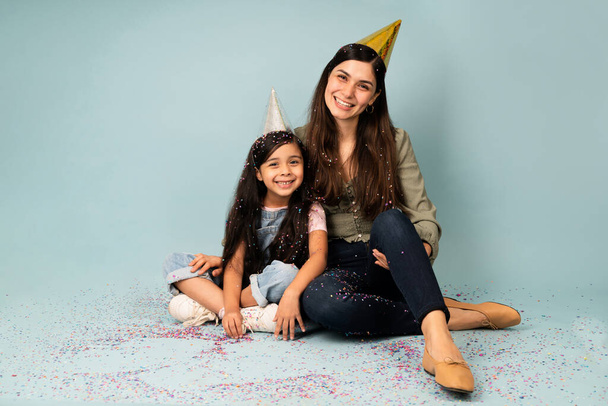 Hermosa joven y su hijita celebrando una fiesta de cumpleaños con confeti - Foto, Imagen