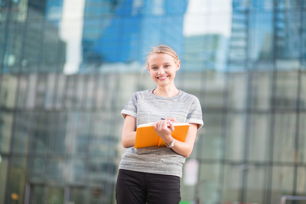 Smiling young woman with notebook - Foto, afbeelding