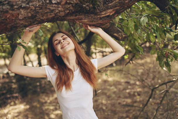 mujer bonita cerca de un árbol al aire libre en el bosque - Foto, imagen