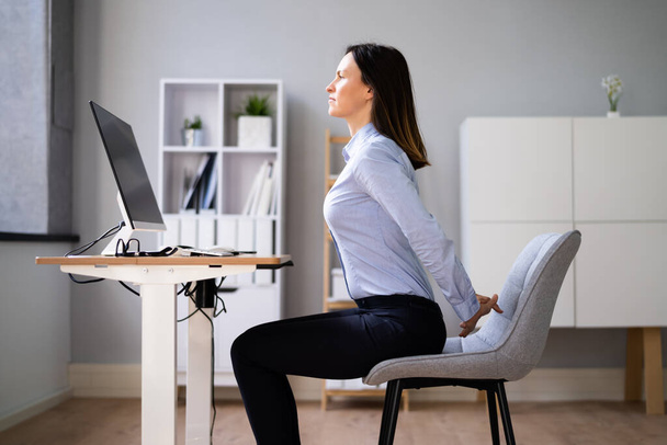 Woman Stretching Arms At Office Desk Near Computer - Фото, зображення