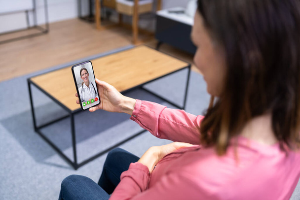Terhes nők orvos videohívás telefonon otthon - Fotó, kép