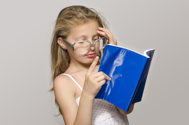 Little girl with eyeglasses reading some books, kid learning, child studying - Foto, immagini