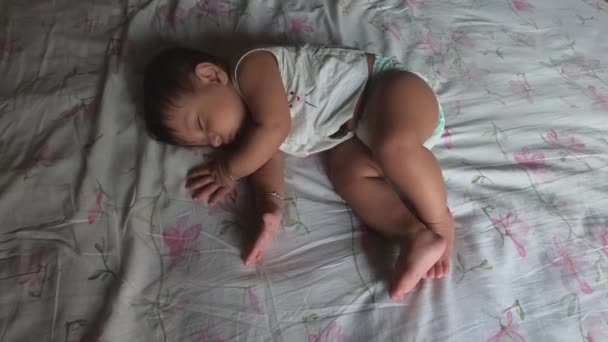 Vauva haukottelu ja venyttely unessa makaa sängyssä juuri ennen heräämistä. Ylhäältä. - Materiaali, video