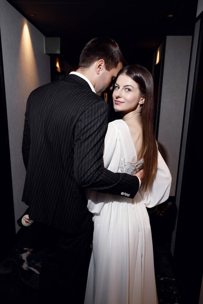 Wedding photo shoot with a lobby and restaurant, on a dark background. Beautiful young bride and groom in a stylish hotel. - Fotografie, Obrázek