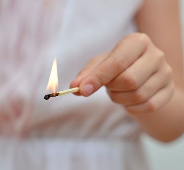 Girl playing with match. Dangerous situation at home. - Photo, Image
