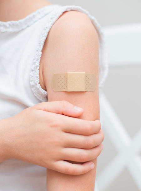 Child arm with an adhesive bandage. - Zdjęcie, obraz