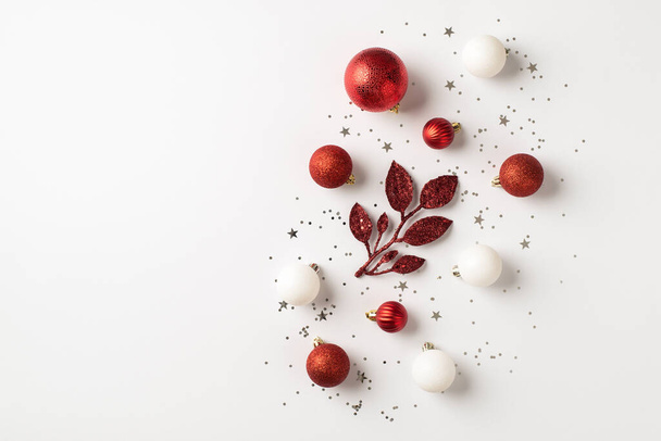 Top pohled fotografie červené a bílé vánoční stromečky dekorace větev koule a stříbrné flitry na izolovaném bílém pozadí s prázdným prostorem - Fotografie, Obrázek