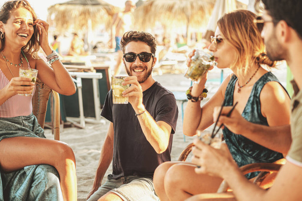 Group of young friends having a party at the beach bar. - Photo, Image