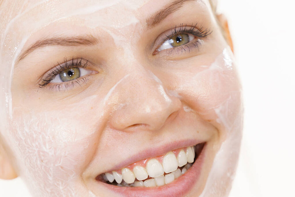 Young woman with cream cosmetic, mask moisture on her face. Beauty treatment. Skincare. - Foto, Imagen